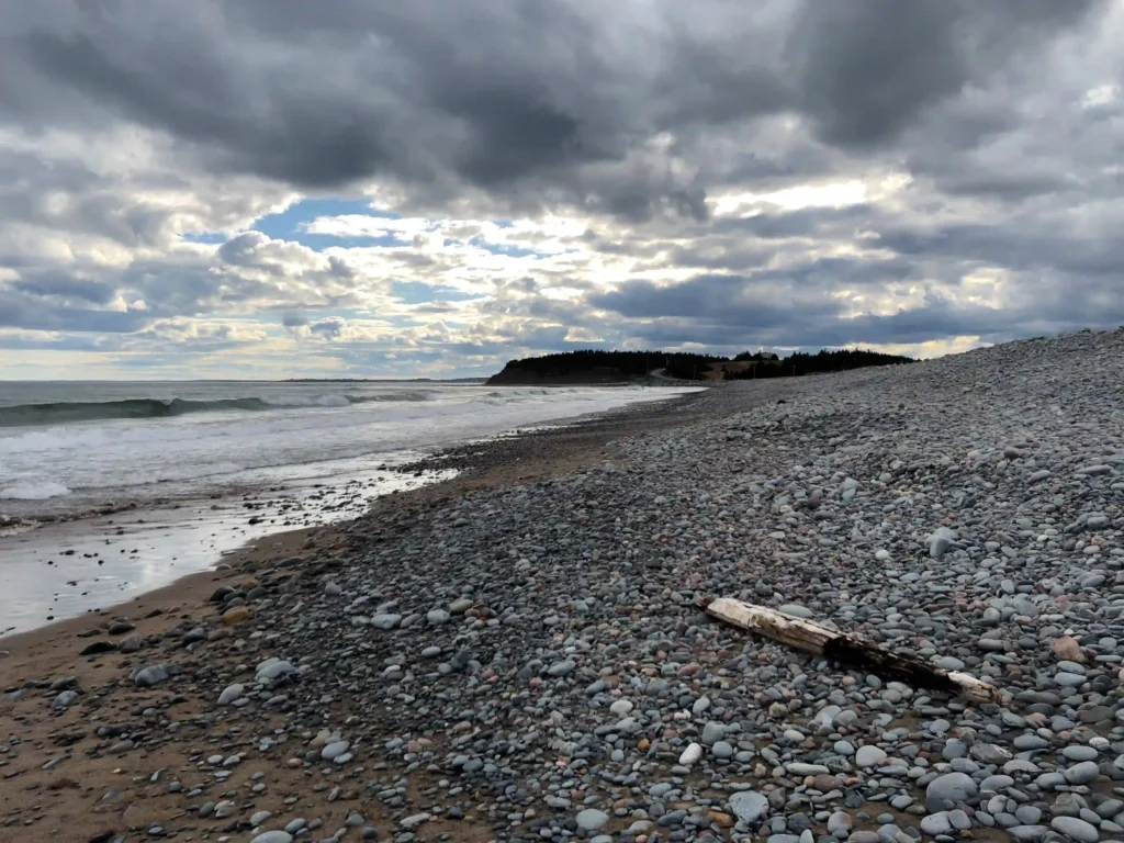 Sand-and-cobble shoreline at Lawrencetown Beach, Nova Scotia, under a cloudy sky