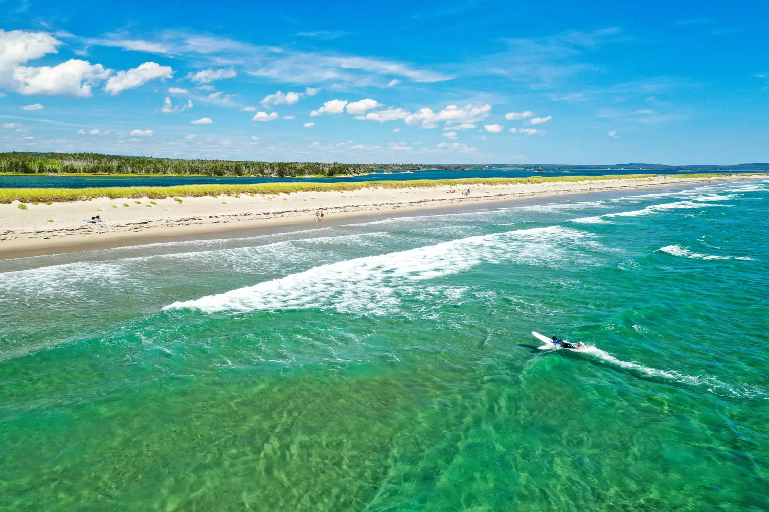 Aerial view of Martinique Beach on Nova Scotia's Eastern Shore, with a long sandy crescent, dunes, and surf rolling in